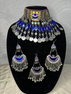 Exquisite Afghan Jewelry Set - Perfect for Special Occasions🇦🇫 Add a touch of exotic elegance to your look with our stunning Afghan jewelry set. Handcrafted by skilled artisans, each piece is a unique work of art that captures the rich cultural heritage of Afghanistan. This set includes a dazzling necklace, matching earrings, and a Tikka headpiece, all intricately designed with traditional Afghan motifs and embellished with vibrant LAPIS LAZULI gemstones. Balochi Doch Jewelry, Ceremonial Multicolor Metal Jewelry, Traditional Adjustable Jewelry With Motifs, Traditional Adjustable Blue Jewelry, Adjustable Ceremonial Jewelry With Motifs, Bohemian Beaded Chandbali Jewelry, Bohemian Chandbali Beaded Jewelry, Handmade Blue Jewelry For Festivals, Traditional Blue Metal Jewelry