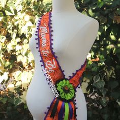 a white mannequin with an orange and purple tie on it's neck