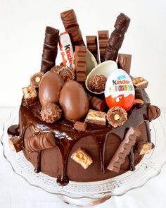 a chocolate cake topped with lots of candy and candies on top of a glass plate