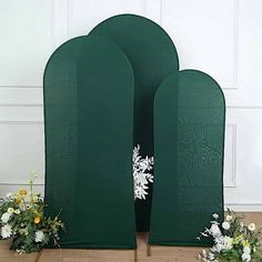 two green archs with flowers on the floor