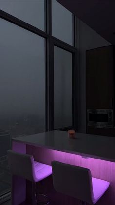 two white bar stools sitting in front of a counter with purple lights on it