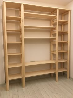 an empty room with wooden shelves and white walls