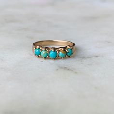 View in 14K Gold. Five 3-millimeter turquoise stones are hand-set in this simple and delicate ring. Click [here] to learn more about this stunning, meaningful gemstone. Not sure about your ring size? Order a ring sizer here! *Note: Photo of loose turquoise stones displays the color variations for this particular piece. You may receive a mix of these colors or all of one color depending on our stock. At this time, we are not able to take special requests for stone color preferences and do no acce Dainty 14k Gold Turquoise Ring, Dainty 14k Gold Turquoise Gemstone Ring, Yellow Gold Turquoise Promise Ring, Dainty Turquoise Ring For Anniversary, Yellow Gold Turquoise Ring For Wedding, Heirloom Turquoise Ring In 14k Gold For Anniversary, Turquoise Yellow Gold Promise Ring, 14k Gold Turquoise Promise Ring, 14k Yellow Gold Turquoise Promise Ring