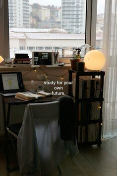 a desk with a laptop computer on top of it next to a book shelf filled with books