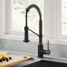 a kitchen sink with a faucet, cutting board and fruit on the counter