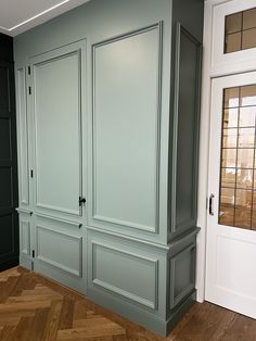 an empty room with green cabinets and wood floors