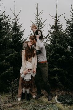 a family standing in front of christmas trees