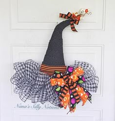 a door hanger with a witch hat and pumpkins on it's side