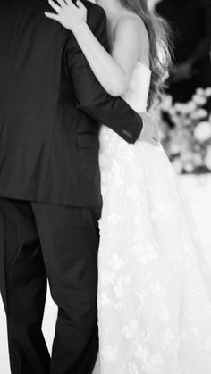 a bride and groom dance together in black and white at the end of their wedding day