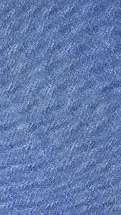 a close up view of a blue denim fabric textured with small speckles