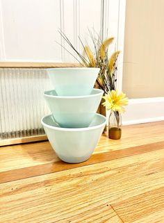 three bowls are stacked on top of each other in front of a radiator