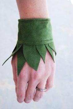 a woman's hand wearing a green leather bracelet