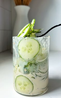 cucumber slices are in a glass with white liquid