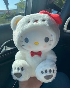 a hello kitty stuffed animal sitting in the passenger seat