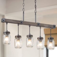 the mason jar chandelier has five lights hanging from it