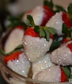 some strawberries are sitting in a glass bowl