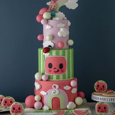 a three tiered cake decorated with pink, green and white icing on a table