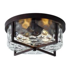 a flush light fixture with clear glass and wood accents on the bottom, in an antique finish