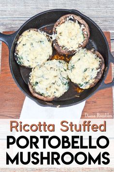 an iron skillet filled with stuffed mushrooms on top of a wooden table