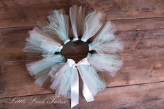 a wreath made out of tulle and white ribbon