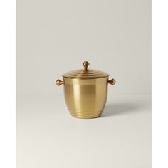 a gold pot with two handles sitting on a white surface