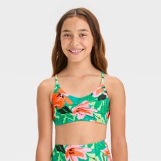 Help your kid create a fresh garden look for beach or pool fun by wearing the "Sun Seeker" Floral Printed Bikini Swim Top from art class™. Covered with dainty floral print, this sleeveless swim top features cinches at the center. This pullover-style top is made from a soft fabric with spandex that offers four-way stretch, and adjustable straps for comfortable wear. It's designed with removable cups for customized coverage, and helps keep them protected from the sun with the UPF 50+ rated fabric. Uv Protection Swimwear For Spring Playwear, Playful Green Swimwear With Uv Protection, Green Swimwear For Summer Beach Activities, Summer Beach Tankini, Playful Green Printed Swimwear, Playful Green Swimwear For Summer Activities, Playful Green Swimwear For Beach Season, Tropical Swimwear For Summer Activities, Spring Playful Tankini For Swimming