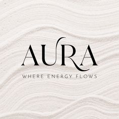 the word aura where energy flows is written in black and white on a sandy surface