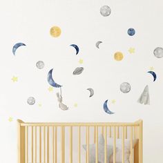 a baby's room with a crib and wall decals