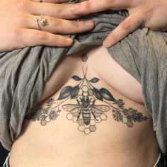 a woman with a bee tattoo on her stomach