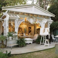 a white gazebo sitting in the middle of a yard