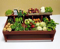 an assortment of fruits and vegetables on display in a wooden tray with white tablecloth