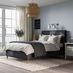 a bedroom with blue walls and white bedding