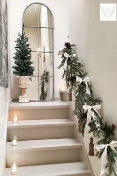 christmas decorations on the stairs in front of a mirror