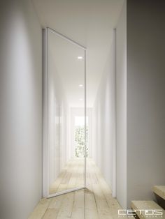 an empty hallway with white walls and wooden floors