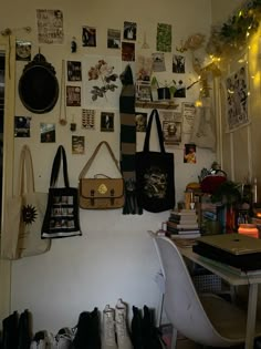 there are many pictures on the wall and purses hanging from the hooks in this room