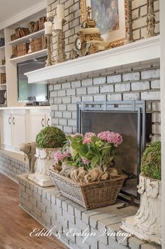 the fireplace is decorated with flowers and potted plants on it's mantel