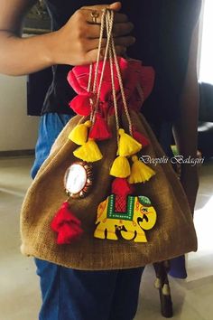 a person holding a brown bag with red, yellow and green decorations