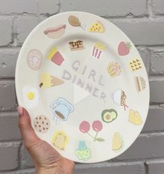 a hand holding a paper plate with the words girl dinner on it