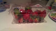 plastic containers filled with strawberries on top of a counter