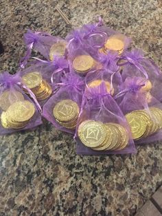 a pile of gold coins sitting on top of a counter next to a purple bag