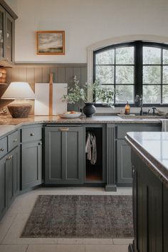 a kitchen with gray cabinets and white counter tops is featured on the instagram page