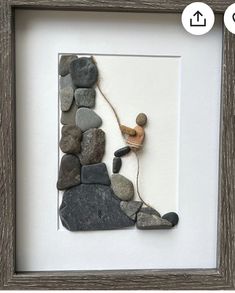 there is a framed photo with rocks and a small toy on the bottom half of it