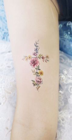 a cross tattoo with flowers on the back of its leg, is shown in an instagram