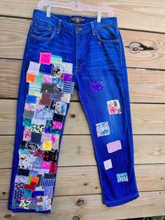 a pair of blue jeans with patchwork on them