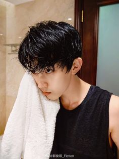 a man with black hair is holding a white towel