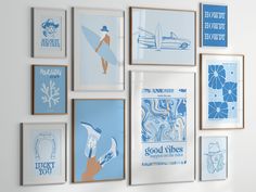 there are many framed pictures on the wall with blue and white artwork hanging above them