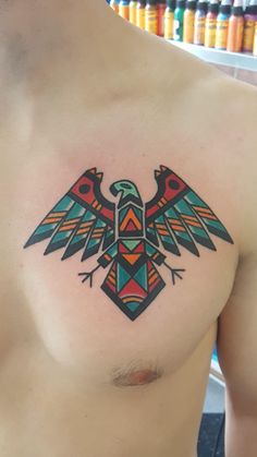 a colorful bird tattoo on the chest