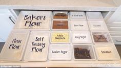 an organized kitchen drawer filled with baking and confection storage containers, labeled baker's flour