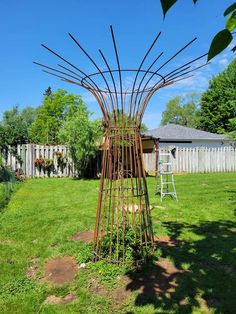 a metal sculpture sitting on top of a lush green field