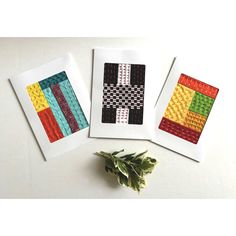 three cards with different designs on them sitting next to each other, one has a green plant in front of it